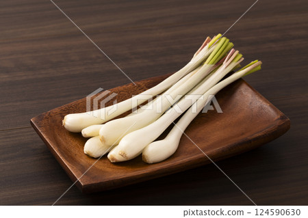 Shallots on a wooden plate on a board 124590630