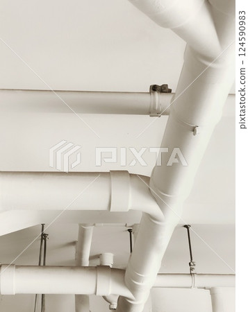 White pipes and ceiling in an industrial building. White pipes and ceiling in an industrial building. 124590983