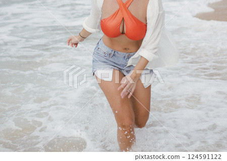 young attractive happy woman dancing twirling on seashore sunny summer fashion style in white shirt and swimsuit vacation young attractive happy woman dancing twirling on seashore sunny summer fashion style in white shirt and swimsuit vacation 124591122