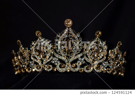 Royal golden crown with citrine gemstones and diamonds on dark background 124591124