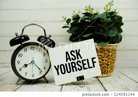 Ask Yourself text on paper card with alarm clock on wooden background Ask Yourself text on paper card with alarm clock on wooden background 124591144