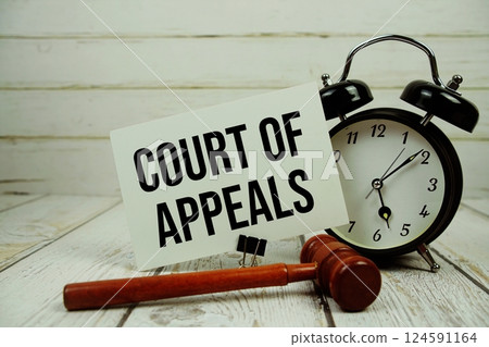 Court Of Appeals text message on paper card with wooden gavel and alarm clock on wooden background 124591164