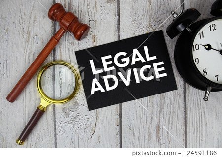 Legal Advice text on paper card with alarm clock and wooden judge gavel top view on wooden background 124591186