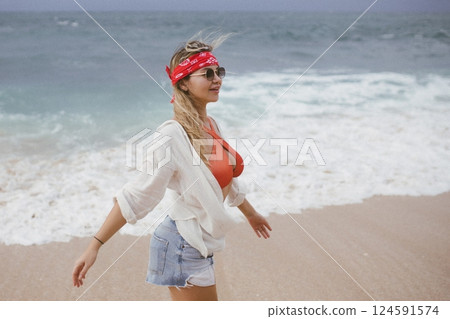 young attractive happy woman dancing twirling on seashore sunny summer fashion style in white shirt and swimsuit vacation young attractive happy woman dancing twirling on seashore sunny summer fashion style in white shirt and swimsuit vacation 124591574