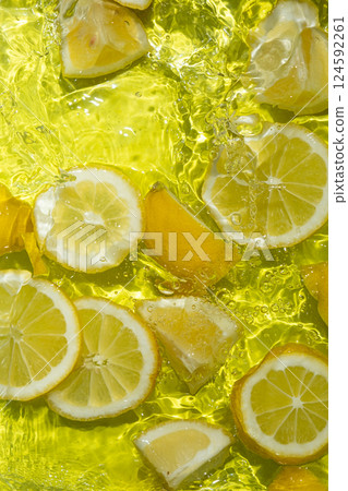 Vibrant yellow lemon pieces floating in motion water Vibrant yellow lemon pieces floating in motion water 124592261