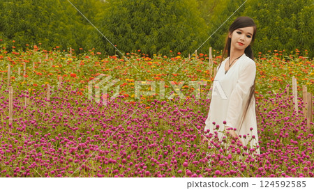 Vietnamese girl with long black hair standing in a plantation purple flowers 124592585