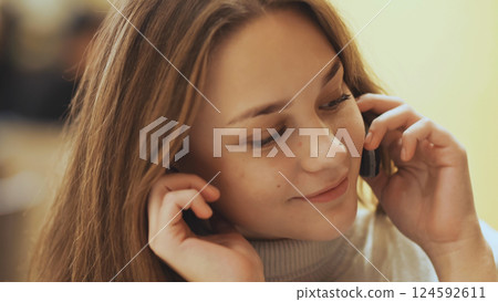 Cute young girl talking on a cell phone. Close-up. Cute young girl talking on a cell phone. Close-up. 124592611