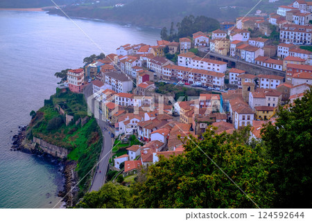 Colorful coastal village with traditional red-roof houses perched on a cliffside by the sea Colorful coastal village with traditional red-roof houses perched on a cliffside by the sea 124592644
