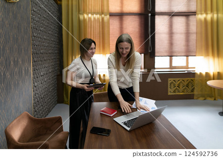 Colleagues collaborating on a project in a modern office while showcasing teamwork and innovation Colleagues collaborating on a project in a modern office while showcasing teamwork and innovation 124592736