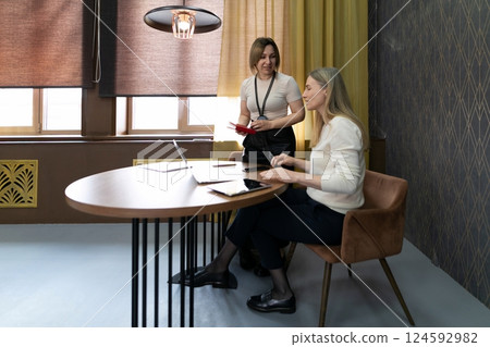 Business meeting discussing project details in modern office setting with warm lighting and stylish Business meeting discussing project details in modern office setting with warm lighting and stylish 124592982