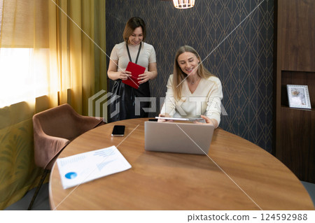 Colleagues collaborating in a bright office space while reviewing project details during the 124592988