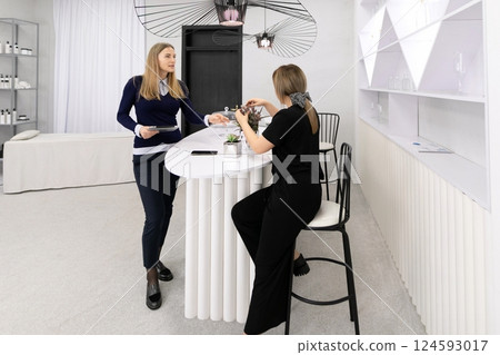 Two women engaging in conversation at a modern interior space during a daytime meeting in a stylish Two women engaging in conversation at a modern interior space during a daytime meeting in a stylish 124593017