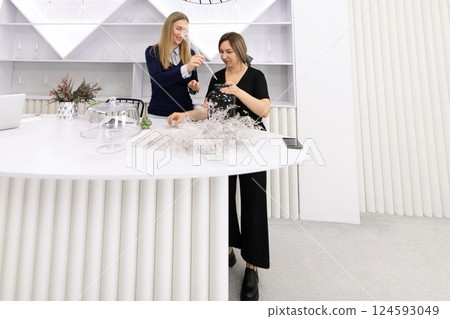 Floral arrangement workshop taking place in a modern studio with two participants creating designs Floral arrangement workshop taking place in a modern studio with two participants creating designs 124593049