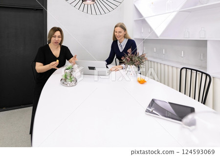 Colleagues engaging in a productive discussion at a modern workspace with a laptop 124593069