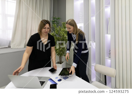 Women collaborating on a project in a modern office space during the day 124593275