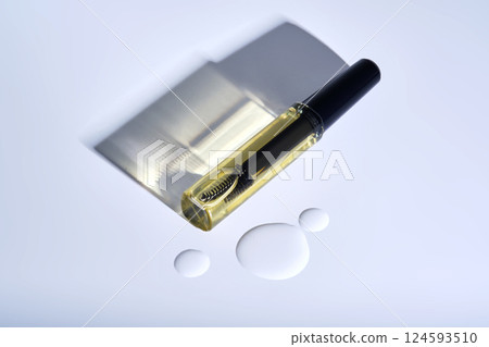 Bottle with brush filled with oil for eyebrow and eyelash growth.  124593510