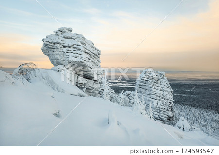 Winter landscape with a bizarre cliff above taiga 124593547