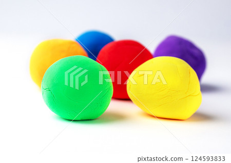 Vivid playdough spheres in a colorful arrangement on a white backdrop 124593833