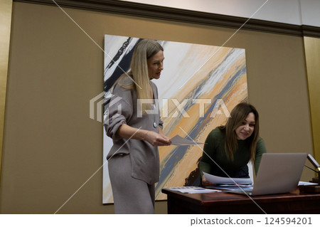 Colleagues collaborating on a project in a modern office setting with abstract art on the wall Colleagues collaborating on a project in a modern office setting with abstract art on the wall 124594201