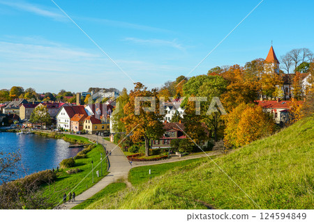 Beautiful view of Talsi Old Town with a white church tower and trees in autumn colors with blue sky 124594849