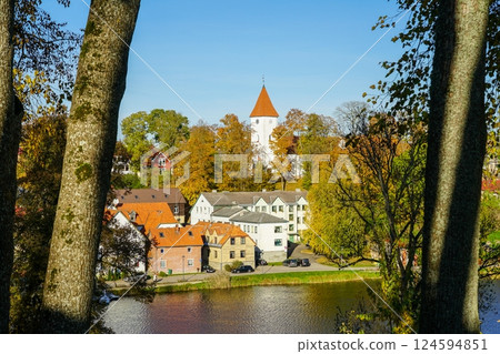 Beautiful view of Talsi Old Town with a white church tower and trees in autumn colors with blue sky Beautiful view of Talsi Old Town with a white church tower and trees in autumn colors with blue sky 124594851