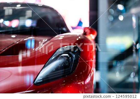 Bold Red Sports Car Front View in Showroom Spotlight, Striking Crimson Performance Vehicle Head-On at Exhibition Display 124595012