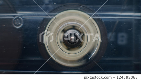 Macro Close Up of Magnetic Tape Reel on Audio Cassette Tape Spinning, Playing Old Music Macro Close Up of Magnetic Tape Reel on Audio Cassette Tape Spinning, Playing Old Music 124595065