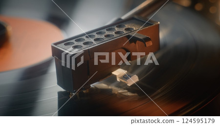 Macro Close Up of Needle Gently Scratching Grooves, Playing Song On Vintage Turntable 124595179