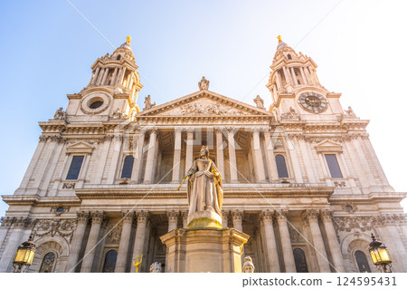 The statue of Queen Anne stands prominently at St. Paul's Cathedral in London, showcasing historical architecture. Sunlight illuminates the grand structure and its detailed features. The statue of Queen Anne stands prominently at St. Paul's Cathedral in London, showcasing historical architecture. Sunlight illuminates the grand structure and its detailed features. 124595431