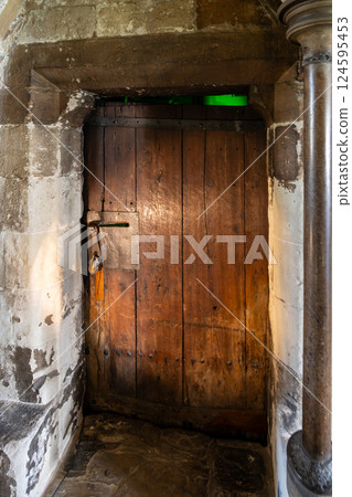 This historic wooden door is found in Westminster Abbey, London. It stands as a remarkable example of medieval craftsmanship, showcasing weathered wood and unique design elements. 124595453