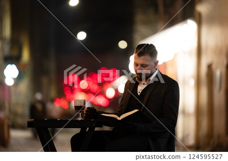 Elegant evening reading with wine in a vibrant urban atmosphere as soft lights illuminate the night in a cozy outdoor setting Elegant evening reading with wine in a vibrant urban atmosphere as soft lights illuminate the night in a cozy outdoor setting 124595527