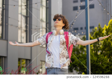 Caucasian young tourist man meditating breathes deeply fresh air taking a break in urban city street 124596288