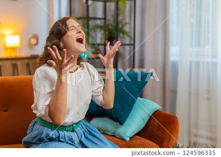 Sad young woman feeling hopelessness loneliness, nervous breakdown, crying shouting sitting on sofa Sad young woman feeling hopelessness loneliness, nervous breakdown, crying shouting sitting on sofa 124596335