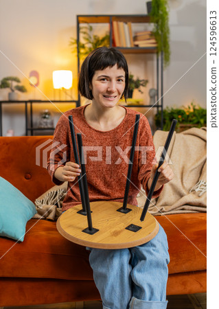 Excited woman finishing assembling furniture table collect, repair, fixing at couch in home room Excited woman finishing assembling furniture table collect, repair, fixing at couch in home room 124596613
