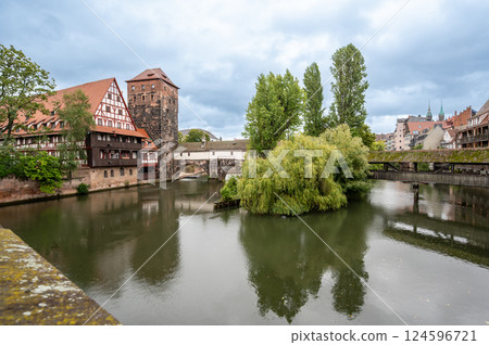 Nuremberg, Germany, August 1, 2023. Photo with an iconic image of the fairytale atmosphere of the place. The half-timbered house is reflected in the water, rainy day. Travel destinations. Nuremberg, Germany, August 1, 2023. Photo with an iconic image of the fairytale atmosphere of the place. The half-timbered house is reflected in the water, rainy day. Travel destinations. 124596721