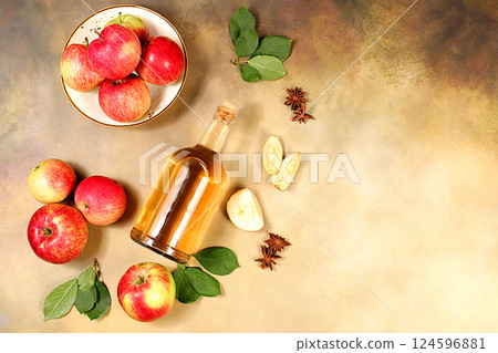 Apple cider, juice, vinegar or fermented drink and fresh apples on a sunny table. Autumn banner. Diet and weight loss concept. Healthy eating, body detoxification, apples help cleanse the body 124596881