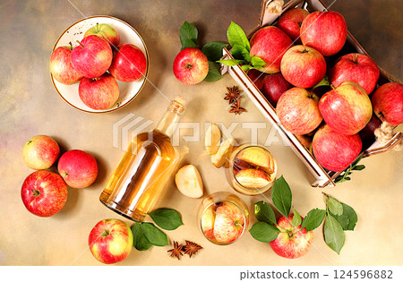 Apple cider, juice, vinegar or fermented drink and fresh apples on a sunny table. Autumn banner. Diet and weight loss concept. Healthy eating, body detoxification, apples help cleanse the body Apple cider, juice, vinegar or fermented drink and fresh apples on a sunny table. Autumn banner. Diet and weight loss concept. Healthy eating, body detoxification, apples help cleanse the body 124596882