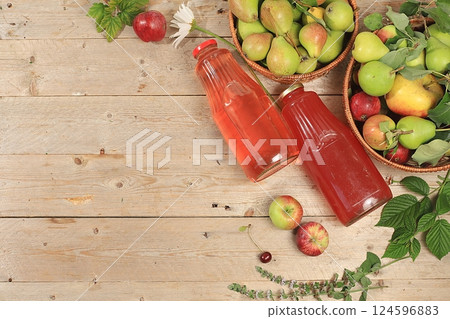 Apple and pear cider, juice or fruit drink in bottles on a wooden table. The concept of diet and weight loss. Apples help cleanse the body and reduce weight. Healthy food, selective focus 124596883