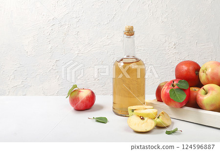 Apple cider drink, juice or fermented fruit drink and ingredients on a sunny table. Autumn banner. The concept of diet and weight loss. Healthy eating, body detoxification, apples help cleanse the 124596887