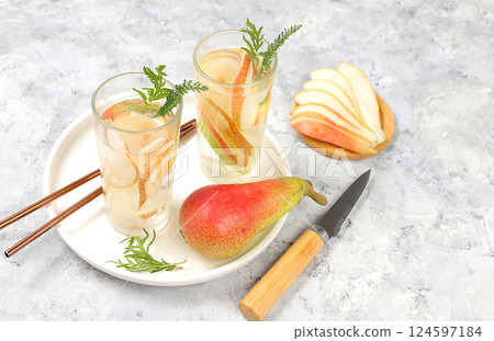 Detox fruit flavored water with pear and mint on a light background. Refreshing summer homemade lemonade cocktail. Fruit juice and ingredients, weight loss concept, healthy and natural food, selective 124597184