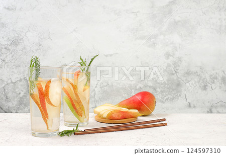 Detox fruit flavored water with pear and mint on a light background. Refreshing summer homemade lemonade cocktail. Fruit juice and ingredients, weight loss concept, healthy and natural food, selective 124597310
