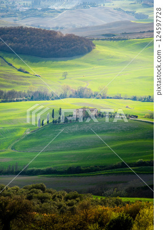 Tuscan farmhouse nestled among rolling green hills and cypress trees in Italy Tuscan farmhouse nestled among rolling green hills and cypress trees in Italy 124597728
