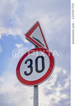 Speed limit sign showing 30 km on background of cloudy sky, cautionary message. Speed limit sign showing 30 kilometers per hour, additional bump warning. Concept of conveys road safety, caution Speed limit sign showing 30 km on background of cloudy sky, cautionary message. Speed limit sign showing 30 kilometers per hour, additional bump warning. Concept of conveys road safety, caution 124597759