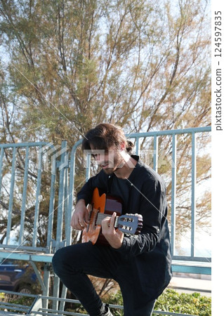 Man Plays Music With Classical Guitar Inexpensive Instrument 124597835
