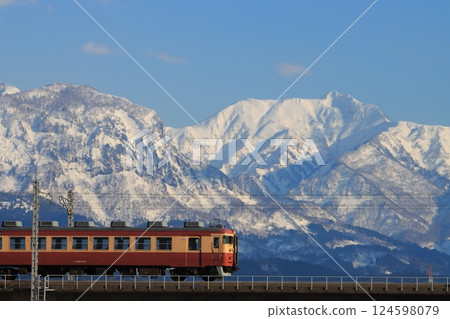 Echigo Tokimeki Railway 413 and 455 series trains running through the majestic Myoko mountains in the background_Photo taken on March 20, 2025 124598079