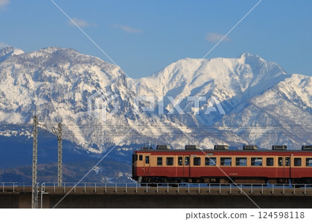 Echigo Tokimeki Railway 413 and 455 series trains running through the majestic Myoko mountains in the background_Photo taken on March 20, 2025 124598118