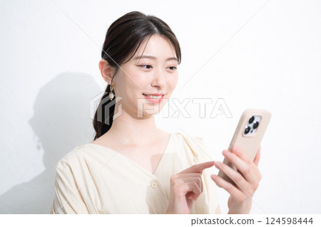 Young woman tapping on smartphone on white background 124598444