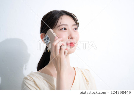 A young woman talking on her smartphone on a white background A young woman talking on her smartphone on a white background 124598449