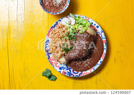 Delicious mole poblano chicken with rice on yellow background 124598807