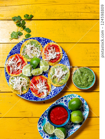 Delicious fried tortilla chalupas poblanas served with vibrant sauces for a festive Mexican celebration 124598809